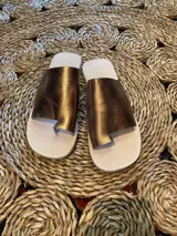Sandalias de cuero color bronce con tira ancha sobre el empeine y diseño de dedo.