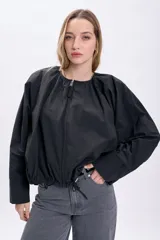 Campera negra corta con frunces en la cintura y cierre frontal.
