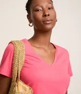 Remera básica de media malla color rosa, con escote en V y mangas cortas.