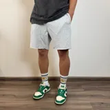Short deportivo gris melange de algodón con corte a la rodilla y ruedo desflecado.
