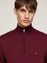 Sweater de punto color borgoña con cuello perkins y cierre de cremallera de un cuarto. Logo de Tommy Hilfiger bordado en el pecho. Confeccionado en algodón.