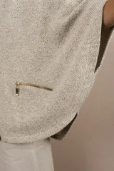 Capa color crudo de lana fina sin teñir, con capucha, cierre frontal y bolsillos con cierre.