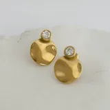 Aros dorados con forma circular irregular y una circonia engarzada en la parte superior.