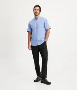 Camisa celeste de manga corta, corte comfort, con cuello abotonado y cierre frontal con botones.
