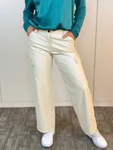 Pantalón cargo color beige de eco cuero, corte recto y bolsillos laterales.