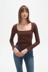 Remera blanca de manga larga y corte ajustado al cuerpo, con escote cuadrado.