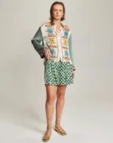 Camisa de manga larga con cuello abotonado y estampado multicolor con flores y cuadros. Tiene un dobladillo redondeado.