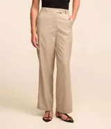 Pantalón de vestir color beige, de corte recto, con trabillas, cintura cruzada y cierre tradicional.