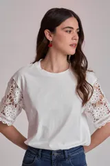 Remera blanca de algodón con mangas cortas de encaje floral.