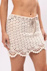 Minifalda color crema tejida a crochet con cintura con cordón ajustable.