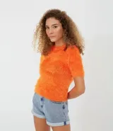 Blusa color naranja con textura de peluche, manga corta y cuello redondo.
