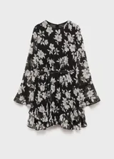 Vestido corto negro con estampado floral blanco, de mangas largas acampanadas, cuello redondo, lazo en la cintura y volados en el ruedo.