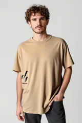 Remera color beige con estampado de rayos negros y texto en la parte inferior.