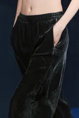 Pantalón de terciopelo negro de tiro medio con cintura elástica, bolsillos laterales ocultos y pierna ancha.
