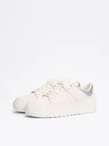 Zapatillas Tommy Hilfiger de corte bajo, color blanco con detalles en plateado en el talón. Confeccionadas en piel, con interior de poliéster y suela de goma. Presentan el logo de la marca en el lateral y en relieve en el talón.