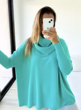 Polerón verde agua de tejido de punto, corte oversize con cuello caído y mangas largas ajustadas.
