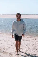 Hoodie celeste claro con capucha y estampado en la espalda que dice "glassy surfer RIDE YOUR OWN WAVE" en color azul oscuro.