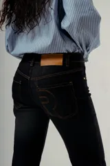 Pantalón de denim color negro lavado, de tiro medio y corte wide leg (pierna ancha y recta con caída fluida).