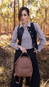 Mochila color mostaza de símil cuero con bolsillo frontal con cierre y broche, apertura superior con cierres metálicos, bolsillos laterales y asa de mano. Incluye bolsillos internos y correas regulables para colgar en la espalda.