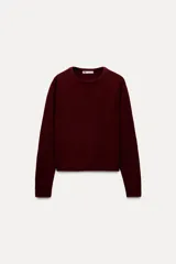 Jersey de punto liso color borgoña confeccionado en 100% lana. Tiene cuello redondo, manga larga y terminaciones en rib.