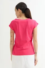 Remera blanca de algodón con cuello redondo y detalle de broderie en el escote.