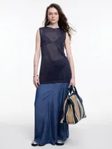 Musculosa sin mangas color gris, tejida en hilado con brillo sutil. De calce relajado y largo por debajo de la cadera, presenta aberturas laterales.