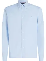 Camisa celeste de popelina de algodón con tecnología Flex, cuello abotonado, corte regular, puños en inglete con dos botones y logo de Tommy Hilfiger bordado en el pecho.
