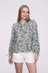 Blusa con estampado multicolor, de corte holgado y mangas largas, con detalle de lazo en el cuello.
