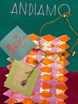 Collar dorado con cadena de eslabones y dijes colgantes de vidrio y resina artesanal con forma de frutas, flores y animales. Cierre con gatillo tipo langosta. Largo de 40 cm + 5 cm de extensión.