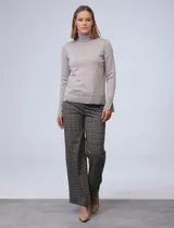 Polera de punto fino marca Nienty, color blanco, con cuello alto volcado y mangas largas con detalle de tajo en los puños.