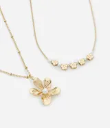 Set de dos collares dorados con dije de flor y perlas.