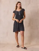 Camisón corto negro con estampado de lunares blancos, escote en V con puntilla blanca y botones.