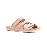 Sandalias bajas de cuero color beige con detalles plateados. Presentan dos tiras con ajuste de velcro sobre el empeine y una tira cruzada sobre los dedos.