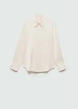 Camisa color crema de tejido fluido con textura y acabado satinado. Tiene cuello clásico, cierre de botones frontal y mangas largas con puños abotonados.