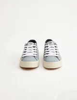 Championes de lona color celeste con detalles en azul marino, cordones blancos y suela color crema.