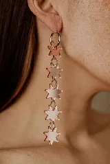 Aros colgantes de acero quirúrgico con aro tipo argolla y cinco dijes de acrílico espejado con forma de estrella.