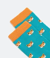Medias de caña larga, color turquesa, con estampado repetitivo de cabezas de zorro en tonos naranja y marrón. Tienen puño, talón y puntera en color naranja.