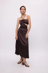 Vestido midi amarillo de satén con escote halter, trenzas en cuello y cintura, cut-outs laterales y falda recta.