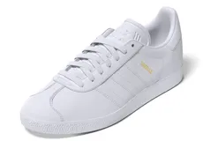 Championes Adidas Gazelle blancos de cuero con las tres tiras características de la marca en los laterales y el nombre del modelo en dorado.