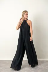 Mono de lurex plisado color negro, con cuello halter y corte ancho.