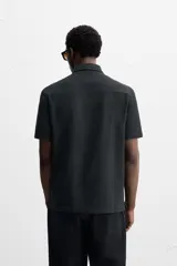 Camisa celeste de corte recto, manga corta y cuello solapa.