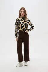 Pantalón de algodón color beige, de tiro alto, corte ancho y largo, con bolsillos frontales tipo parche.