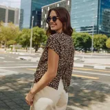 Camiseta beige con estampado animal print de leopardo, de corte holgado, mangas cortas y espalda abierta con lazo.