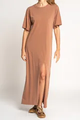 Vestido largo color visón de algodón con cuello redondo y mangas cortas. Presenta un tajo alto en el frente.