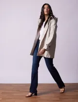 Gabardina impermeable color beige, marca Weatherproof, con abertura central con botones, bolsillos delanteros y capucha desmontable.
