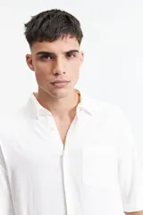 Camisa negra oversize de manga corta con cuello clásico y bolsillo en el pecho.