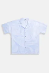 Camisa estilo camper, de fit boxy, confeccionada en popelina con estampa de mármol celeste y blanco. Tiene cuello tipo camp-collar y botones de madera.