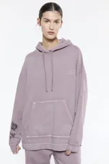 Buzo oversize de algodón peruano, color gris, con capucha, manga larga y bolsillo tipo canguro.