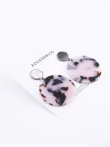 Aros colgantes con base circular negra y dije circular con estampado animal print en tonos blanco y negro.
