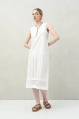 Vestido largo color beige, sin mangas, confeccionado en algodón con calados verticales y bordado tipo ojo de perdiz.